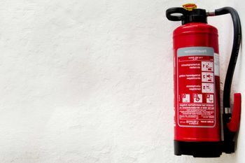 Person prüft einen Feuerlöscher