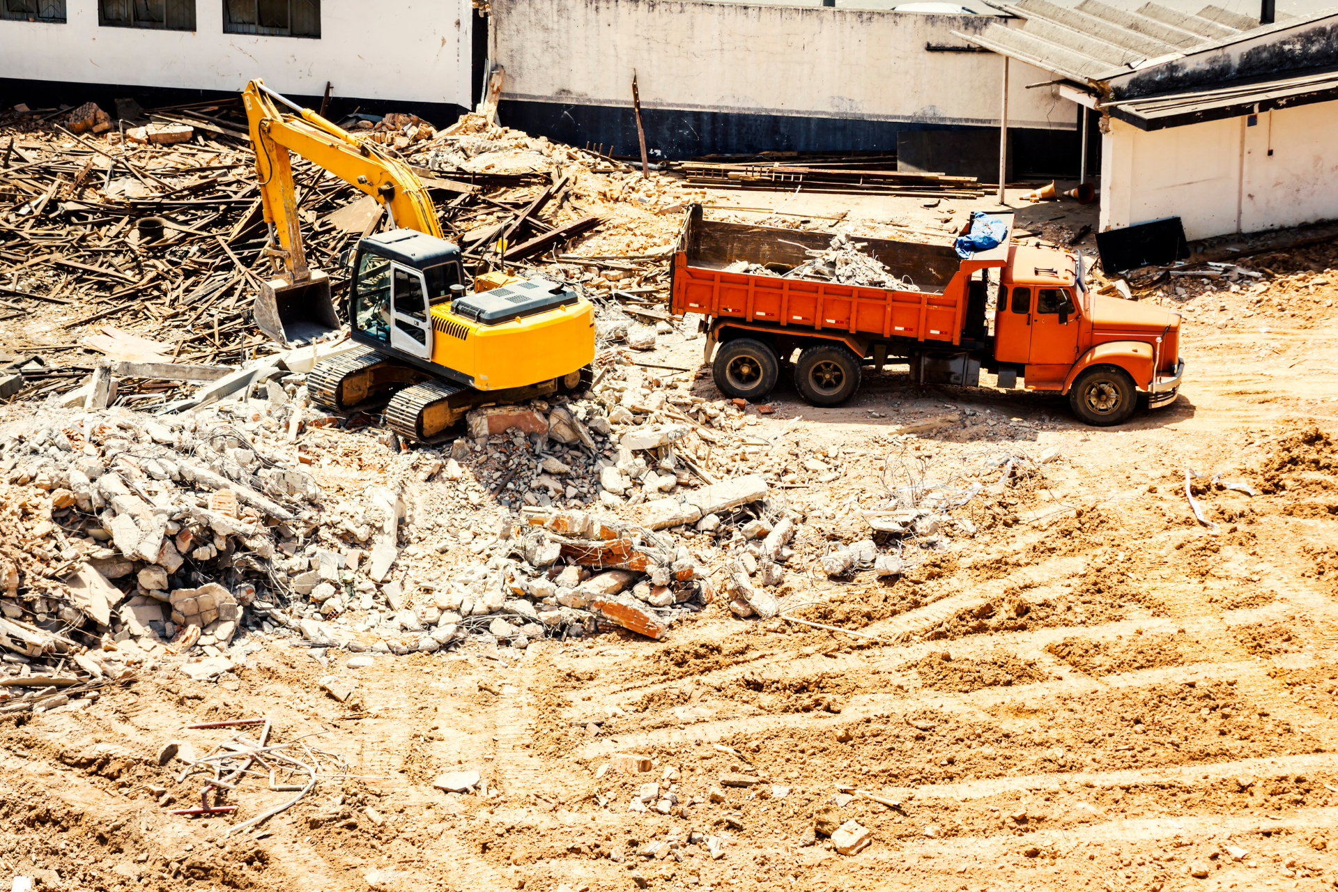 Une excavatrice et un camion à benne basculante travaillent sur un chantier de construction.