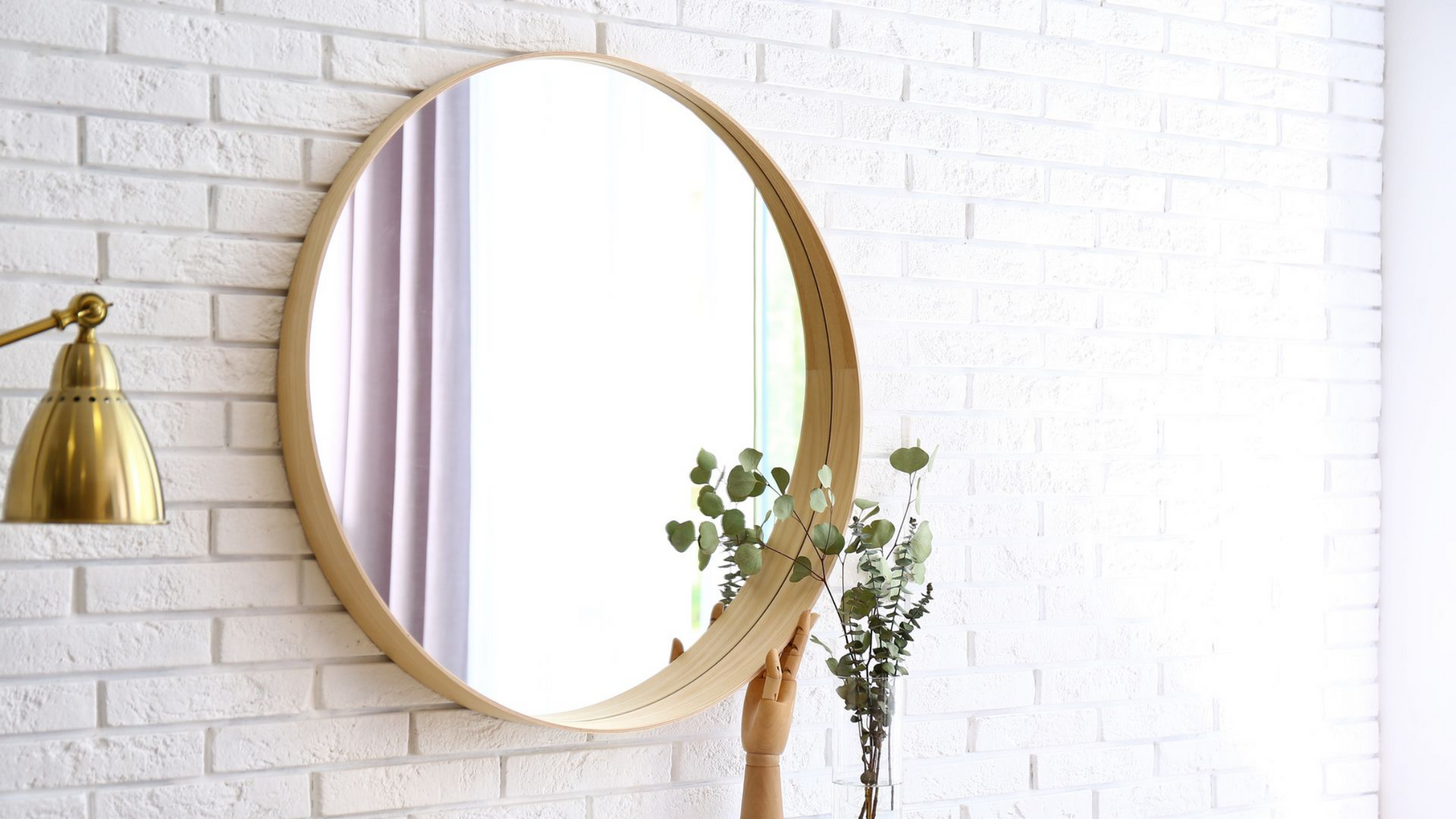 Un grand miroir rond sur un mur de salle de bains.