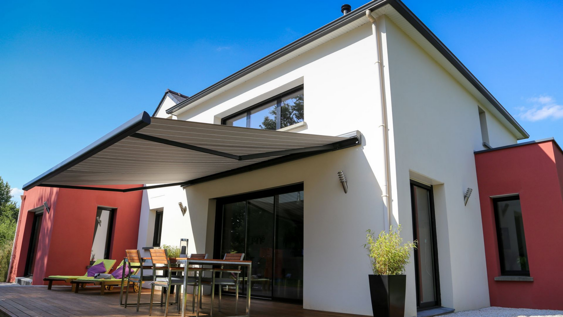 Un store banne au-dessus de la terrasse d'une maison moderne.