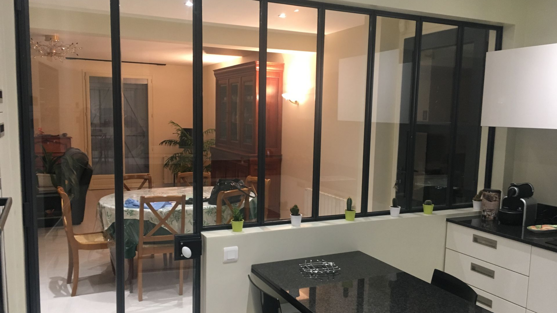 Une verrière entre une cuisine et un salon.