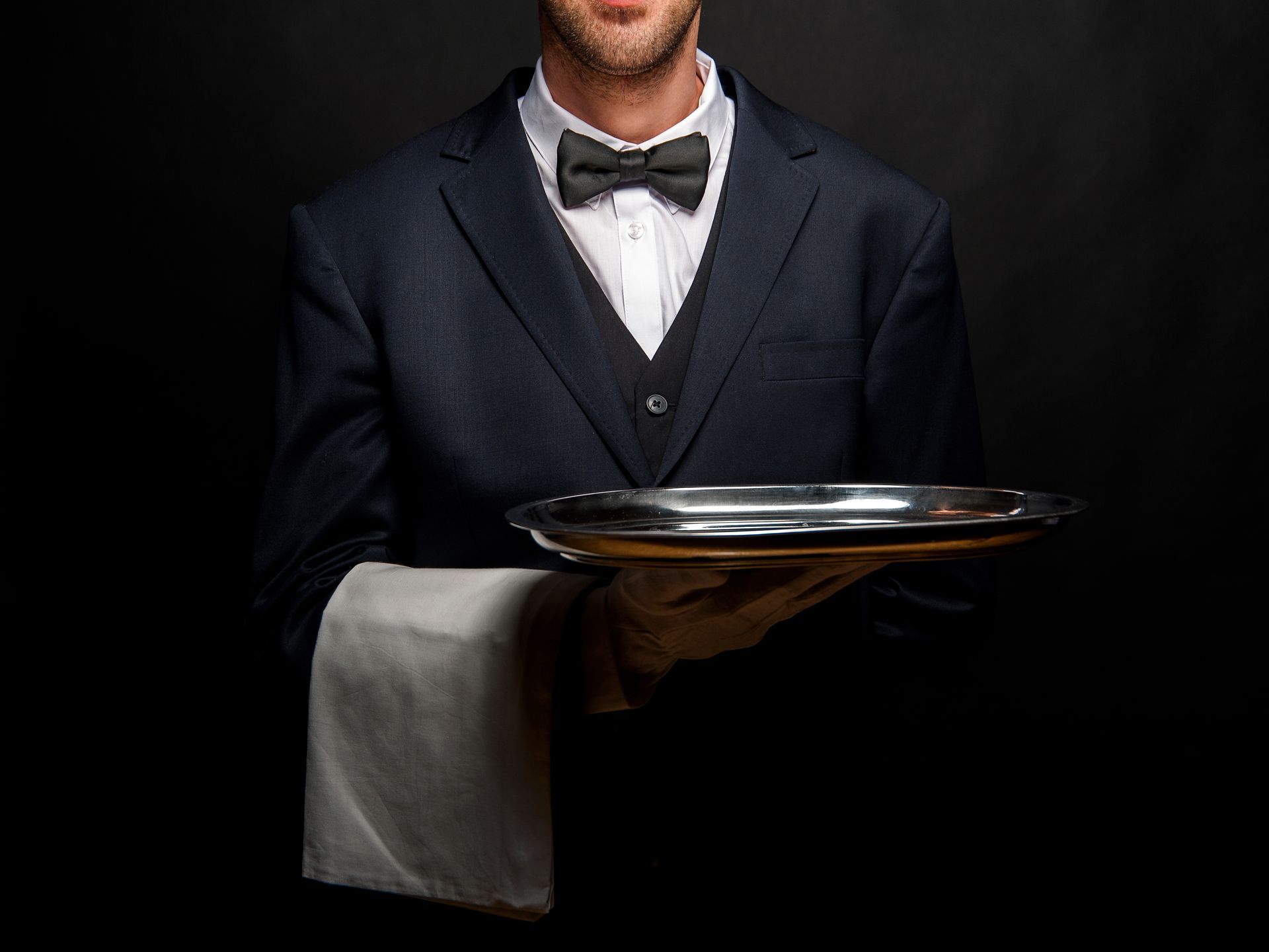 Serveur avec nœud papillon tenant un plateau