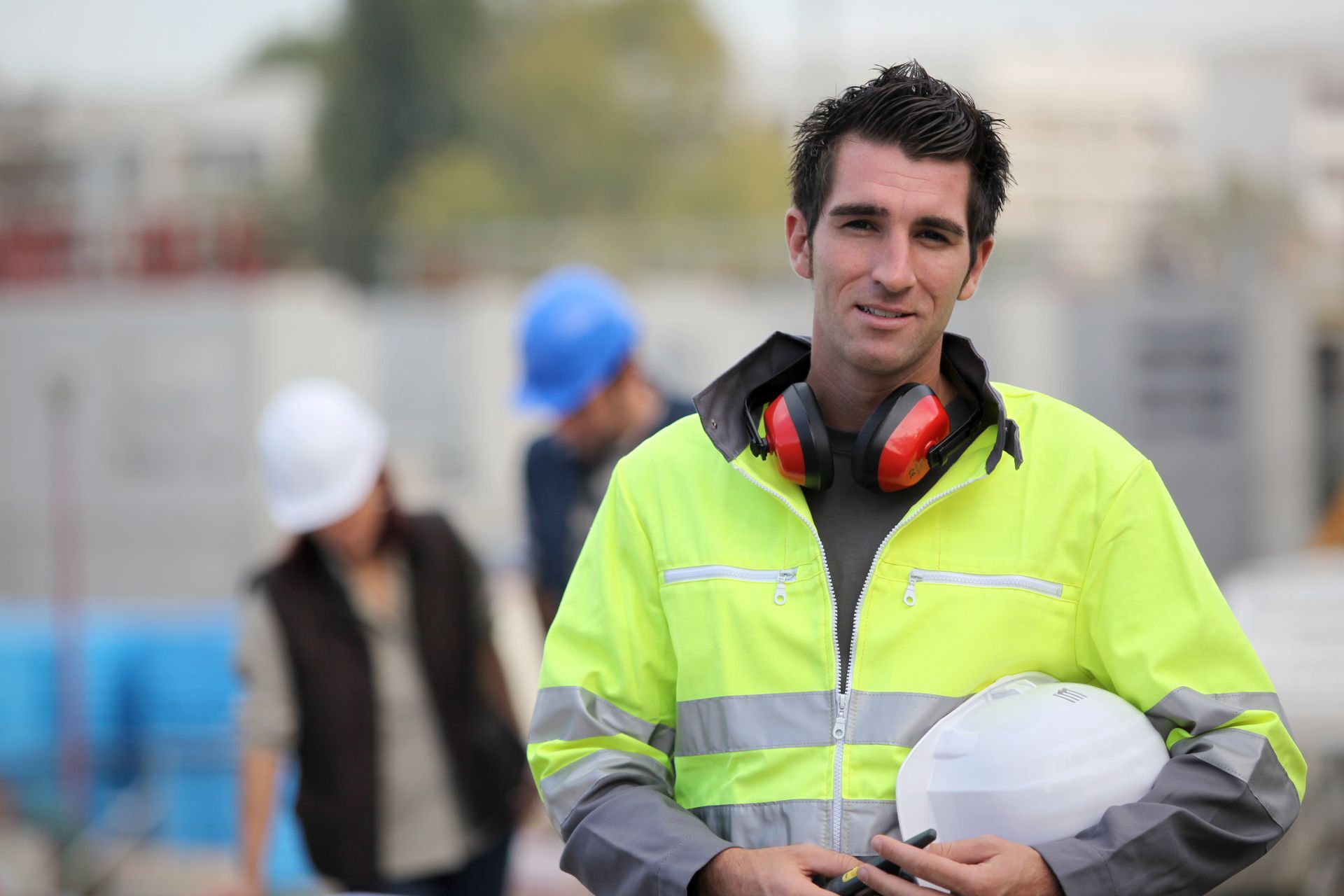 Homme en gilet jaune avec un casque de chantier dans un environnement lié au BTP