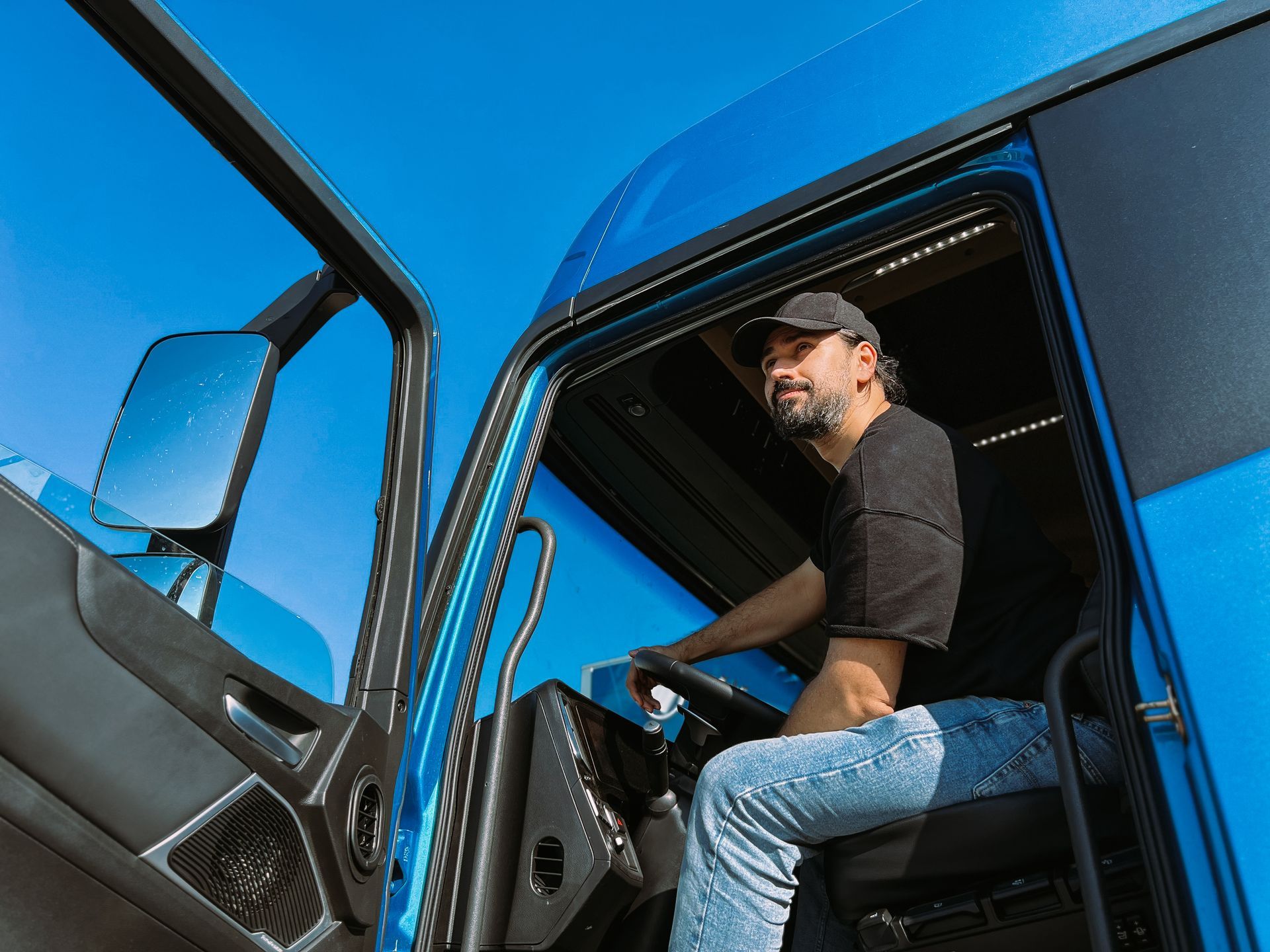 Un conducteur de camion avec la porte ouverte regardant au loin