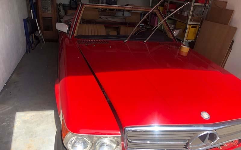 Ein rotes Auto ist in einer Garage neben einer Mauer geparkt.
