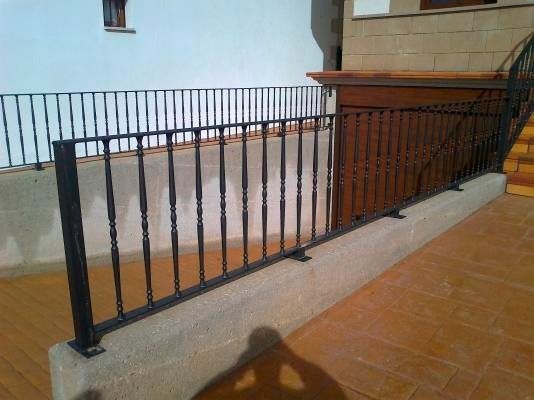 Una valla de hierro forjado rodea una escalera en un edificio.