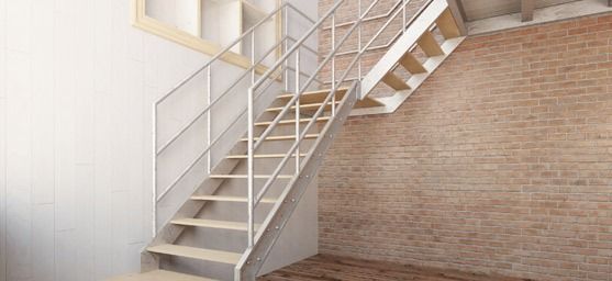 Una escalera en una habitación con una pared de ladrillo.