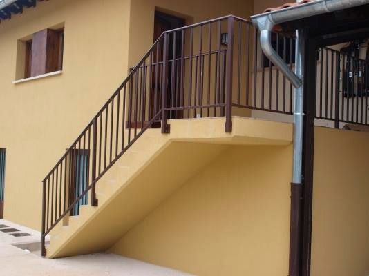Una casa amarilla con escaleras que conducen al segundo piso