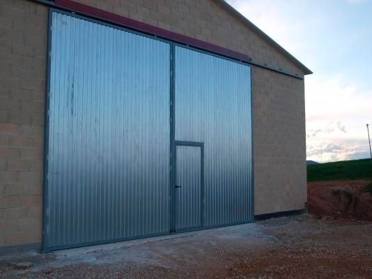 Una gran puerta de metal está en el costado de un edificio.