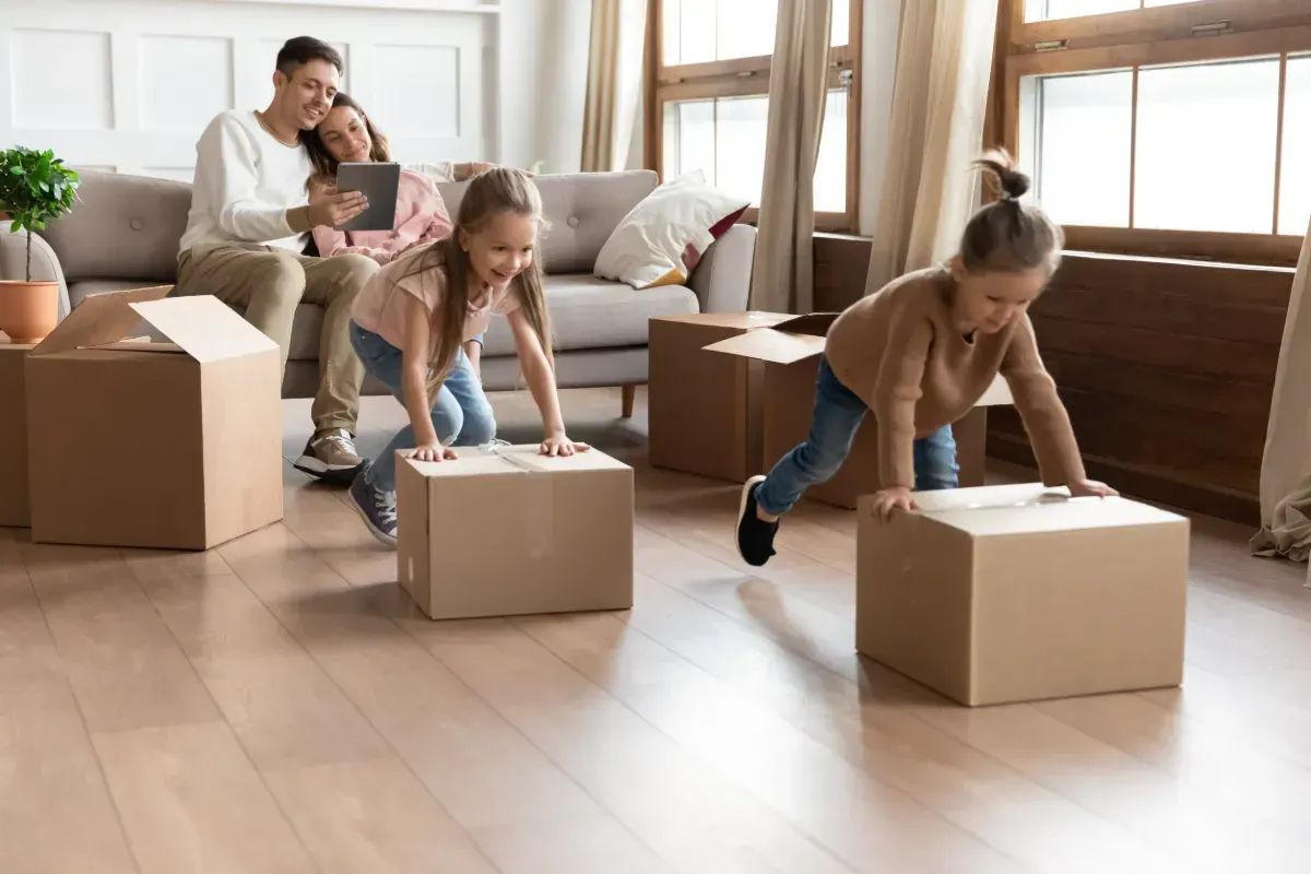 Una familia se muda a una nueva casa y juega con cajas de cartón.