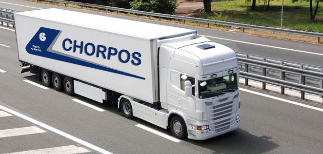 Un camión blanco con la palabra chorpos en el costado circula por una autopista.