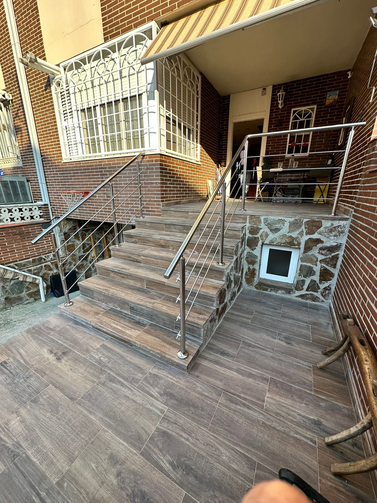 Un balcón con un edificio de ladrillo al fondo.