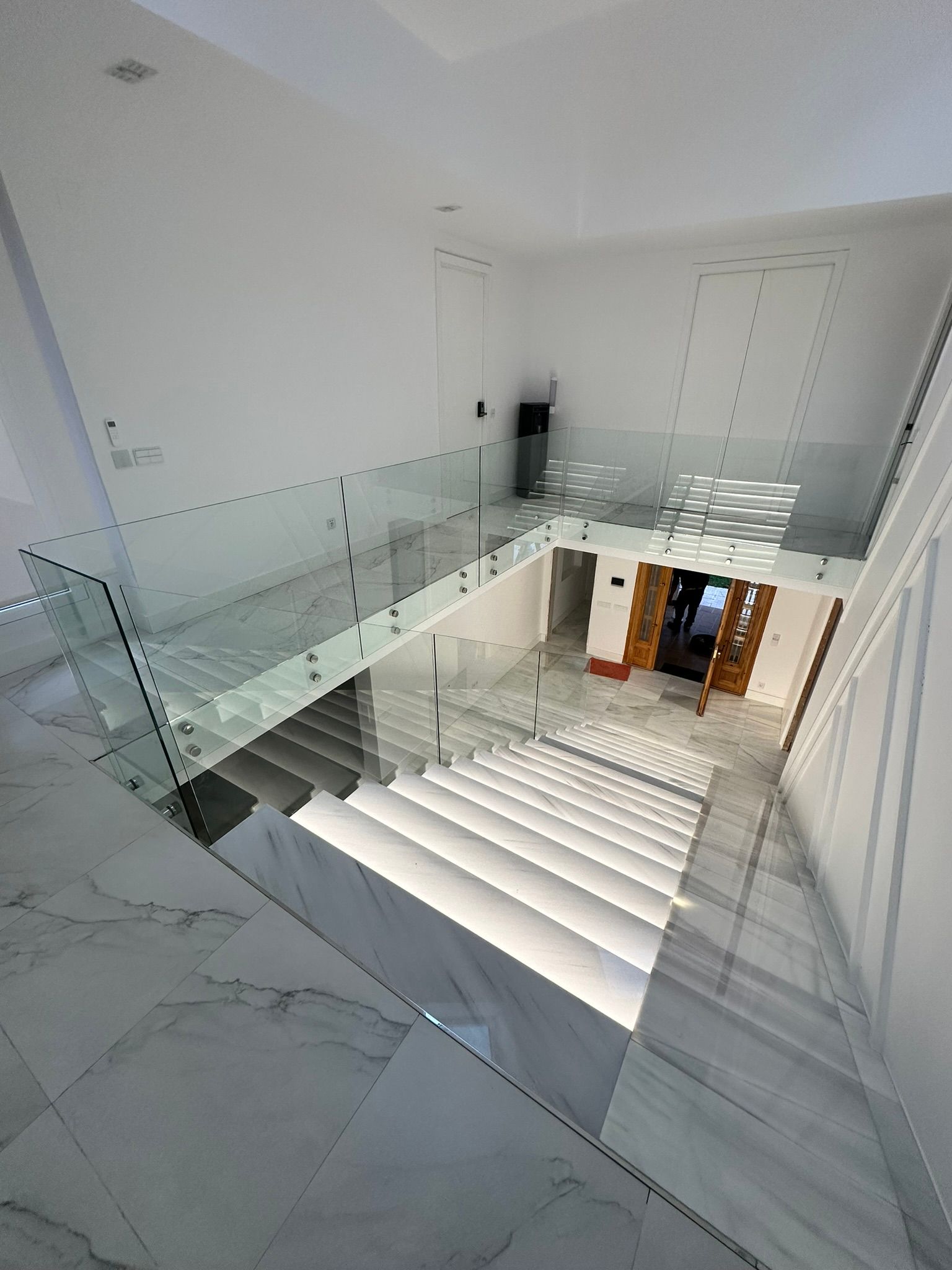 Una escalera con barandilla de cristal en una casa.
