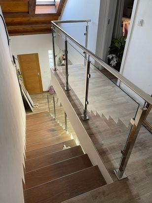 Un conjunto de escaleras con barandilla de vidrio en un edificio.