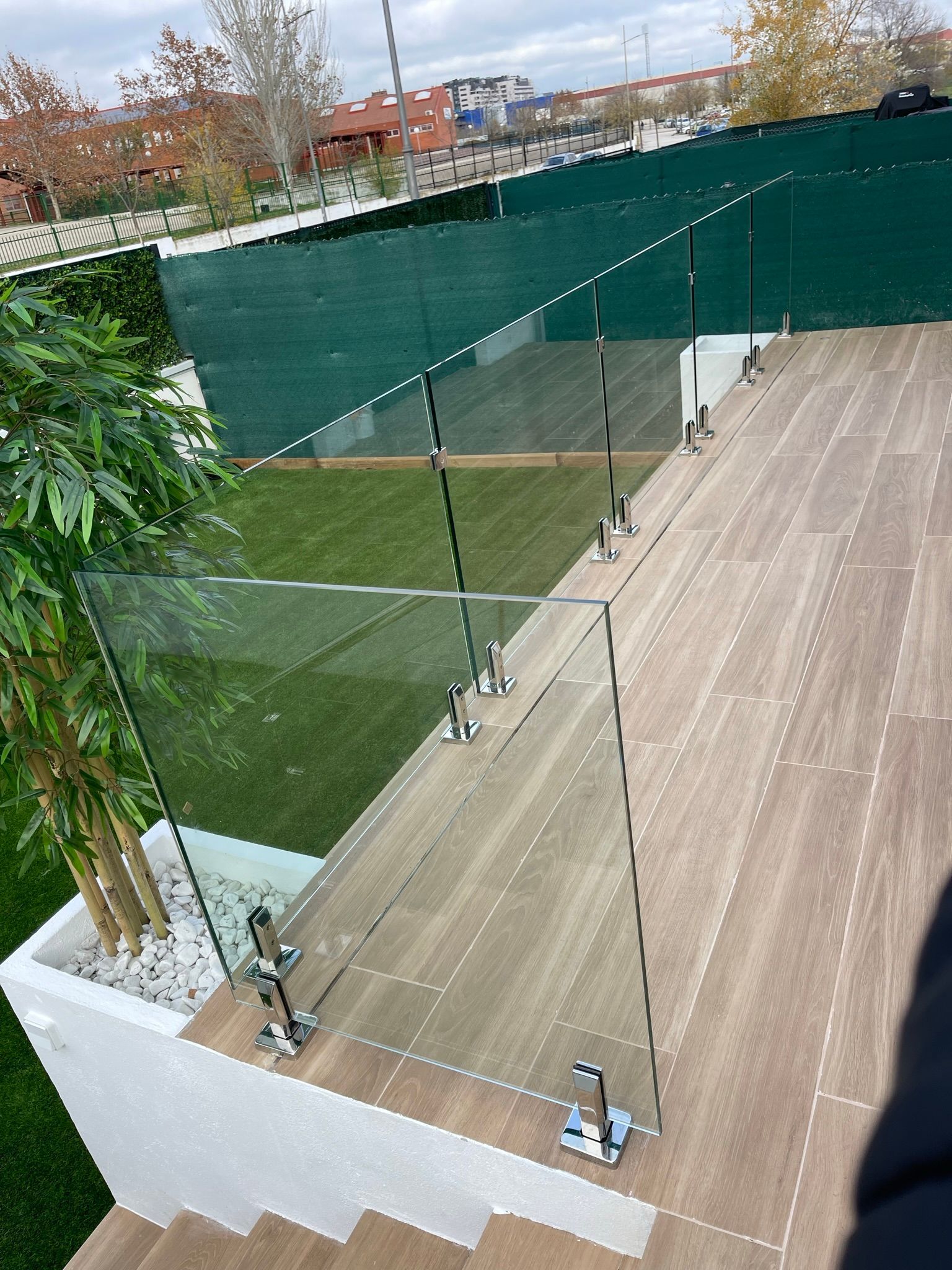 Una escalera de madera con barandilla de vidrio transparente.
