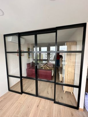 Una habitación con una mesa y sillas y una puerta corrediza de vidrio.