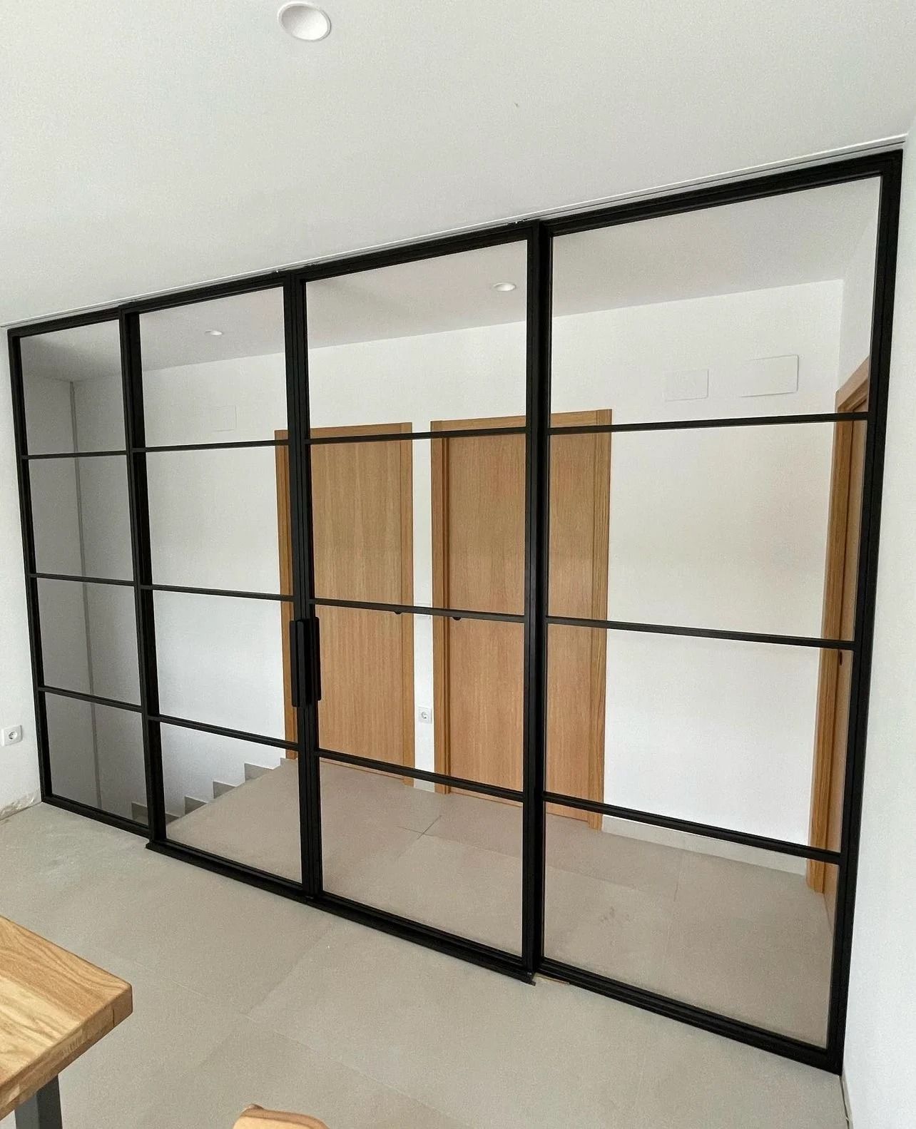 Una habitación con puertas corredizas de vidrio y una mesa de madera.