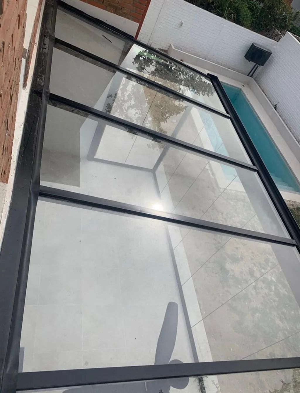 Un dosel de cristal sobre una piscina en una casa.