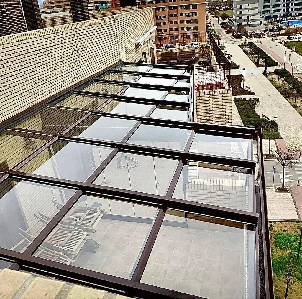 Una marquesina de cristal en la parte superior de un edificio con una ciudad al fondo