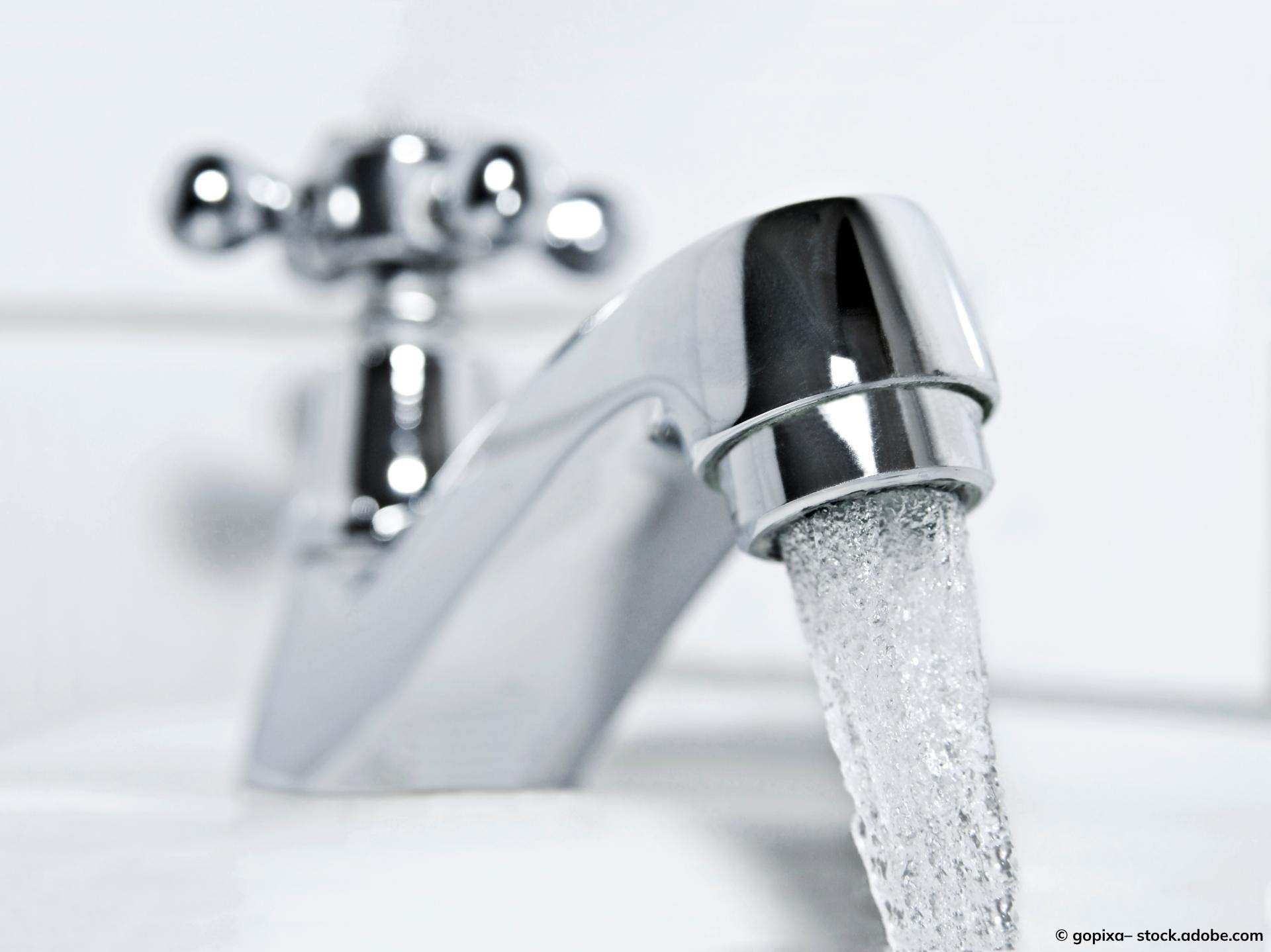 Wasser fließt aus einem Edelstahl-Wasserhahn