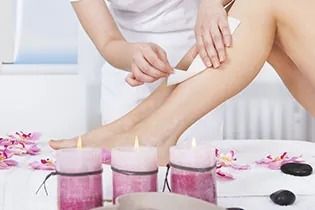 Una mujer se depila las piernas en un salón de belleza.