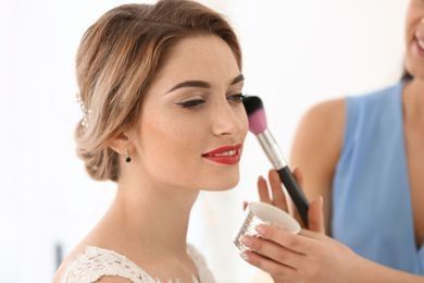 Una mujer está aplicando maquillaje en la cara de otra mujer.