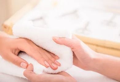Una mujer se envuelve las manos en una toalla.