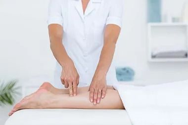 Una mujer está dando un masaje de piernas a un paciente en un spa.