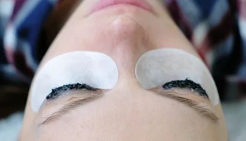 Un primer plano del rostro de una mujer con parches en los ojos.