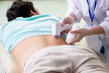 Un médico le realiza una ecografía en la espalda a un hombre.
