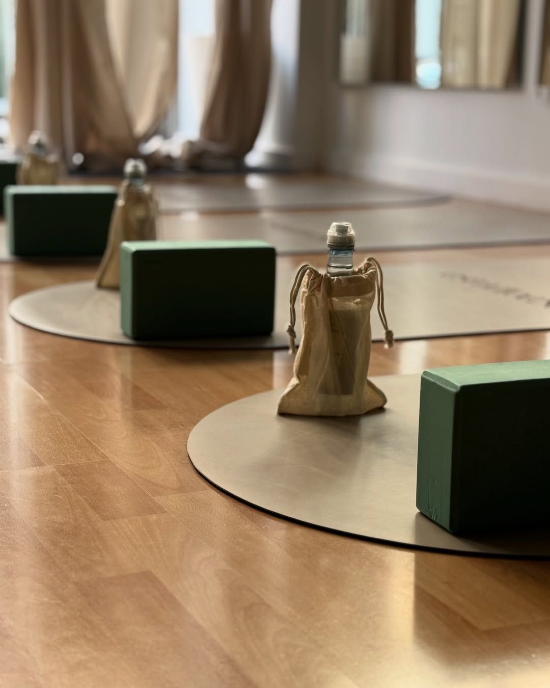 Una fila de bloques de yoga verdes sobre un piso de madera.