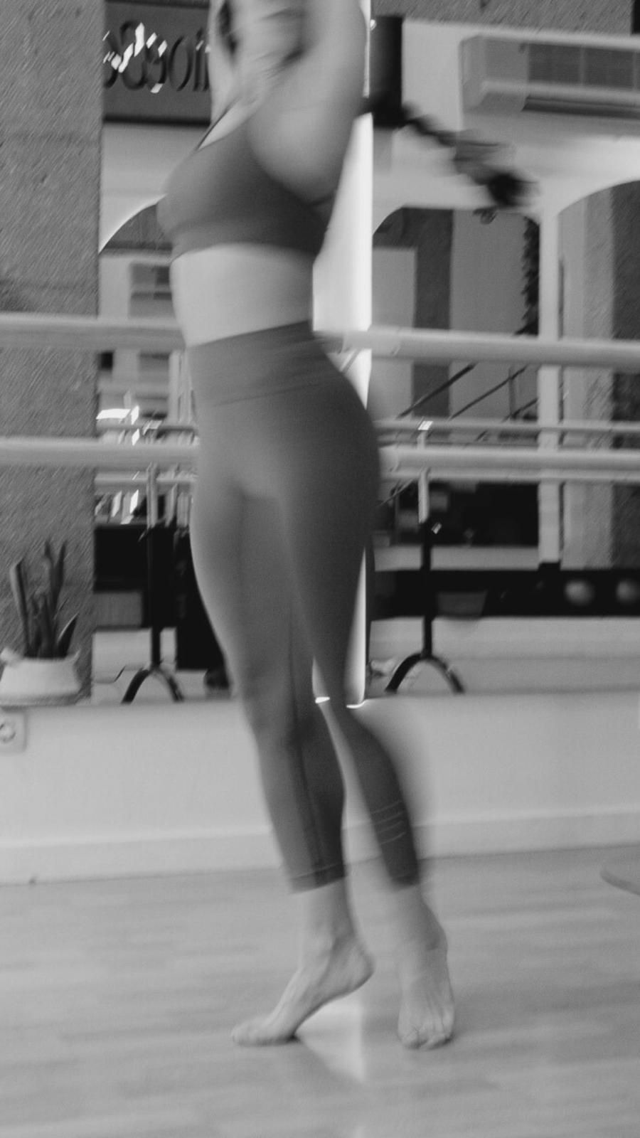 Una fotografía en blanco y negro de una mujer bailando en un estudio de danza.