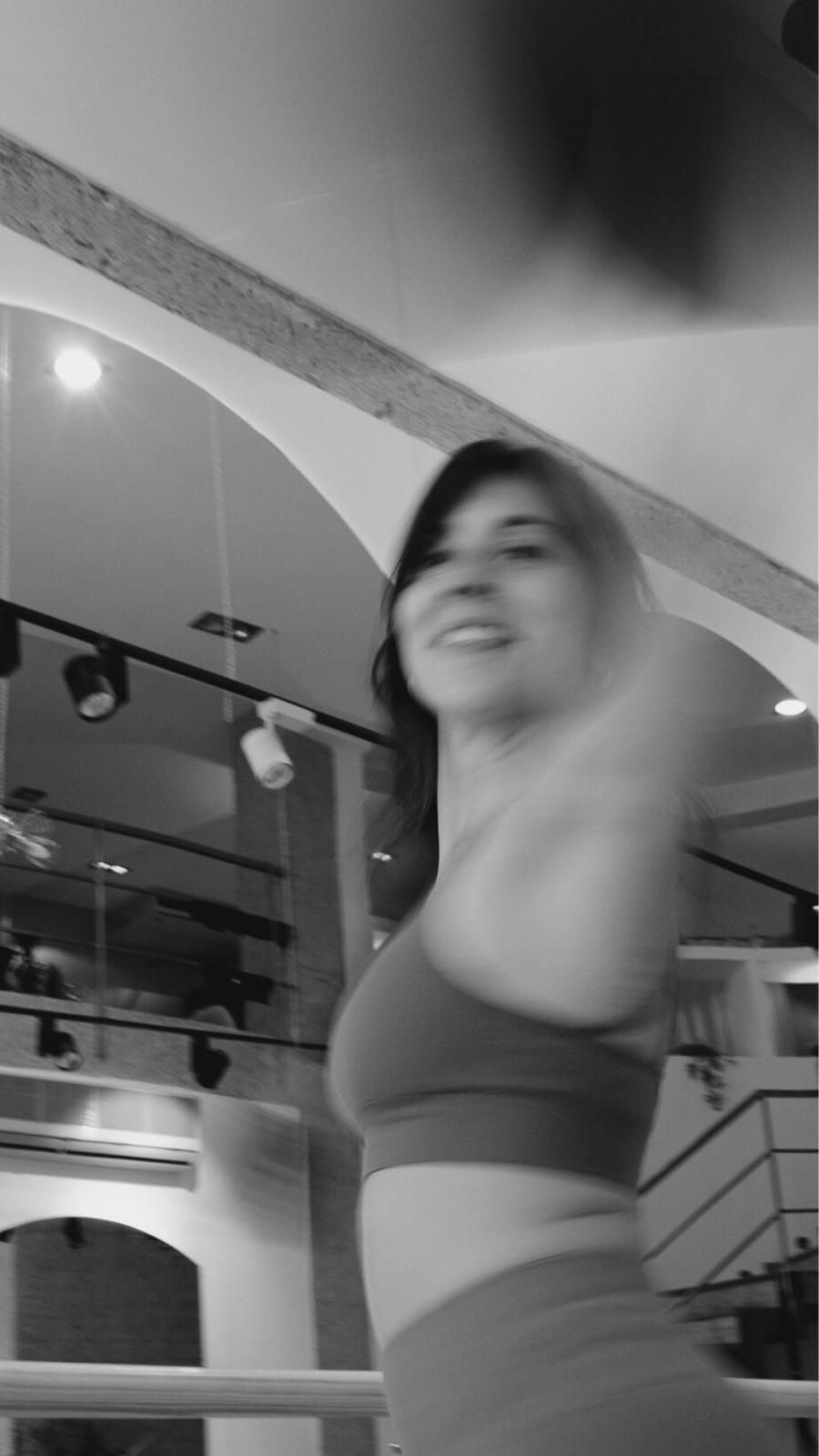 Una fotografía en blanco y negro de una mujer bailando en un gimnasio.