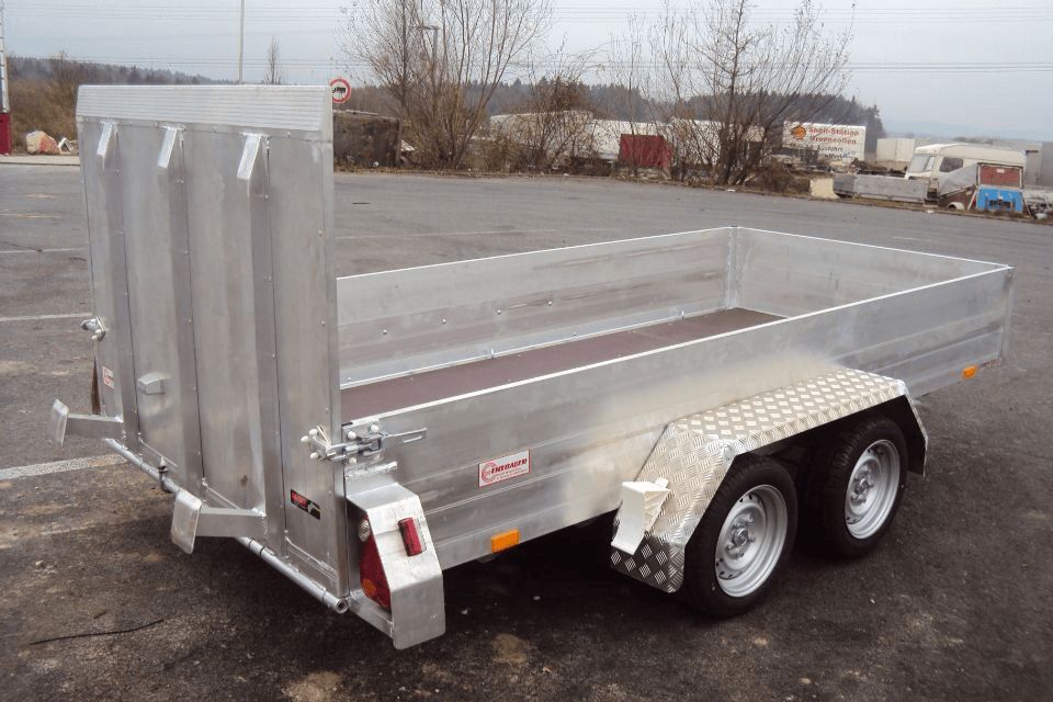 Aluminium-Nutzanhänger mit Seitenwänden und zwei Rädern, im Freien geparkt.
