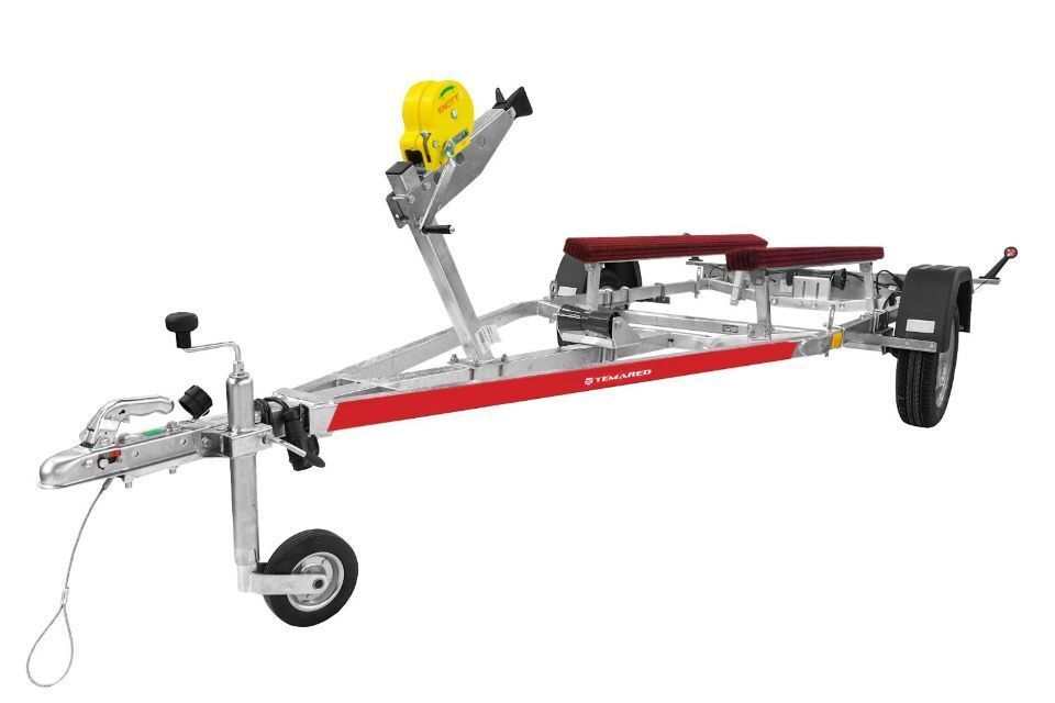 Bootsanhänger, überwiegend silber mit roten Akzenten. Verfügt über eine gelbe Winde und zwei rote gepolsterte Stützen.