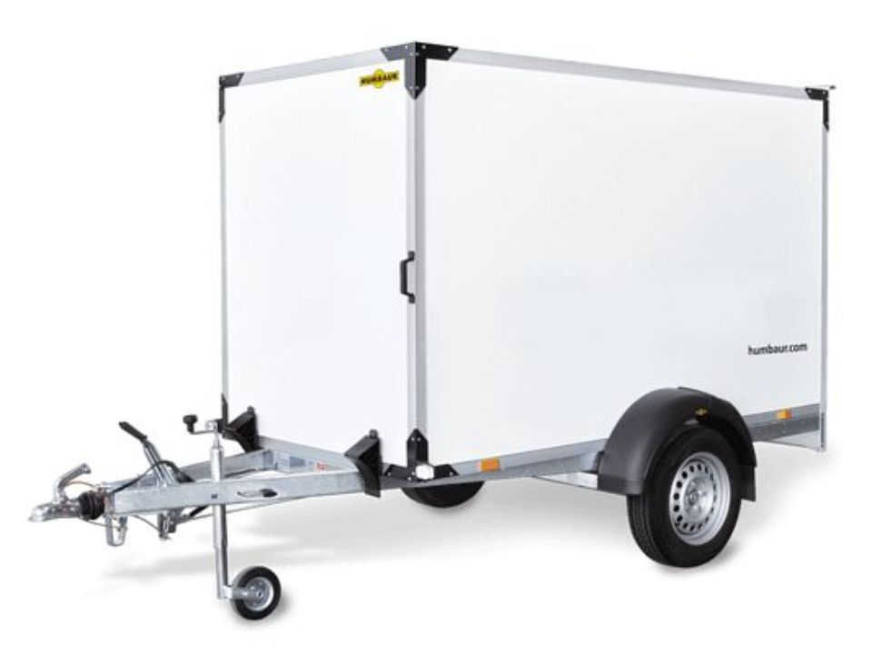 Weißer geschlossener Frachtanhänger, an ein Fahrzeug angehängt, mit einer einzelnen Tür und einem schwarzen Radkasten.