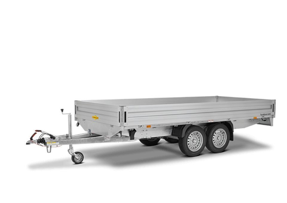 Ein Pritschenanhänger mit Doppelachse, Anhängerkupplung und erhöhten Seitenschienen aus Metall.