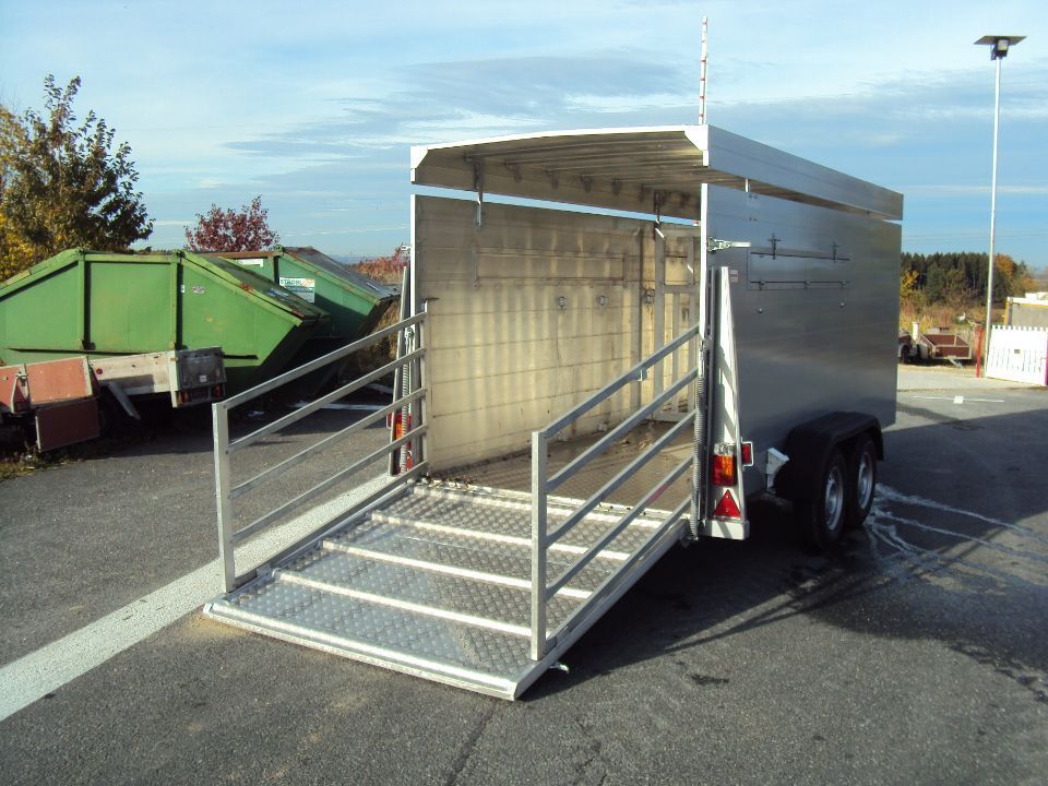 Aluminium-Nutzanhänger mit geöffneter Rampe, auf Asphalt geparkt.