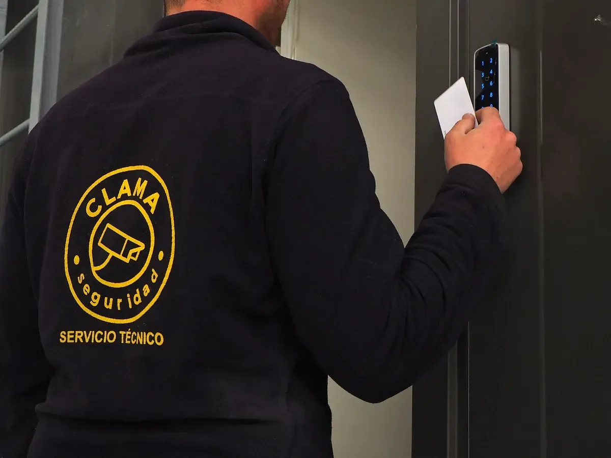 Un hombre que llevaba una chaqueta negra con un logo de Clasa amarillo en la espalda.