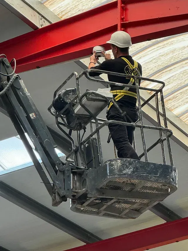 Un hombre que lleva un casco está trabajando en una grúa.