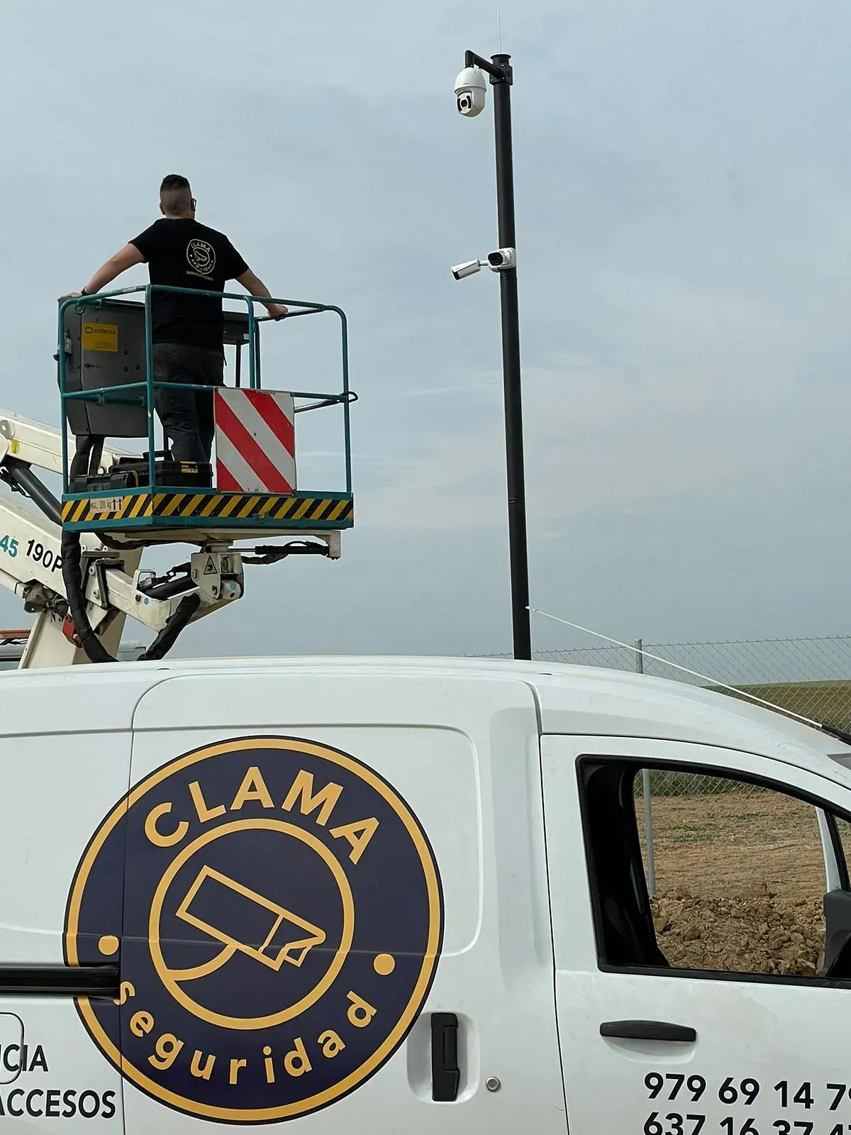 Un hombre está parado en un cubo encima de una camioneta Clam