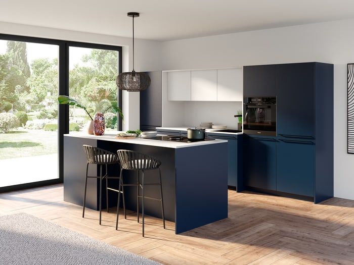 Moderne Küche mit dunkelblauer Kochinsel, weißen Oberschränken, Edelstahlgeräten und großen Fenstern.