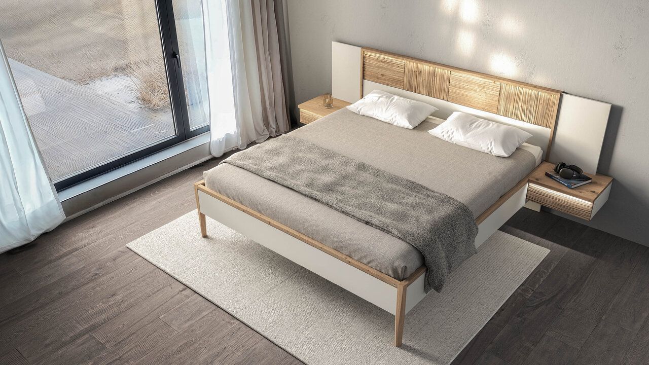 Draufsicht auf ein modernes Schlafzimmer mit Holzbett, heller Bettwäsche, schwebenden Nachttischen und einem großen Fenster.