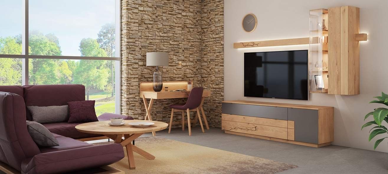 Wohnzimmer mit einem lila Sofa, Couchtisch, Schreibtisch und einem modernen Entertainment-Center aus hellem Holz vor einer Steinwand.