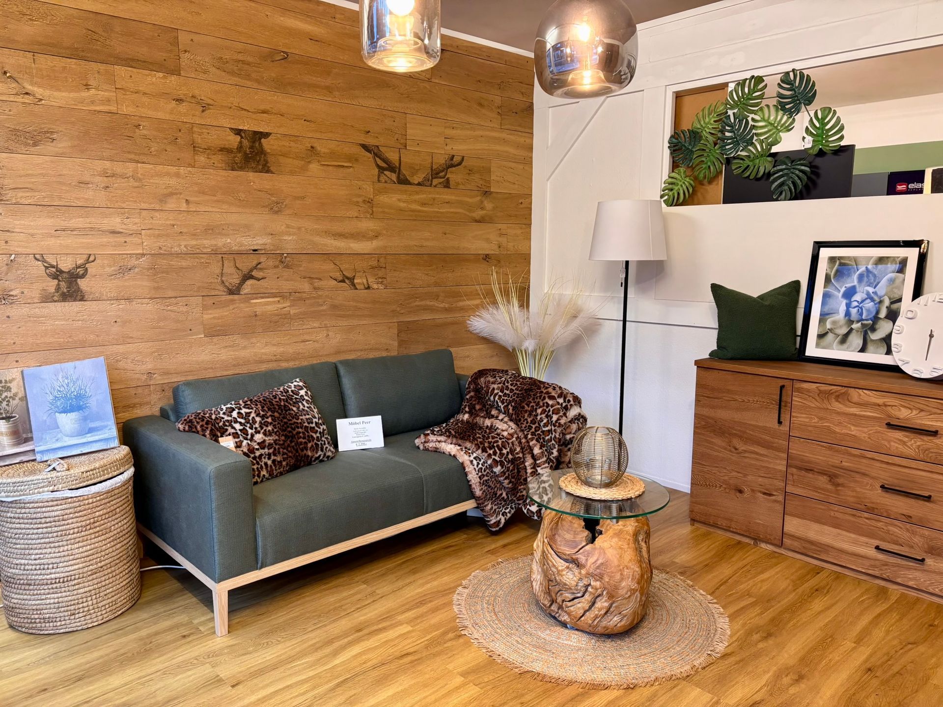 Ein gemütliches Wohnzimmer mit grünem Sofa, holzgetäfelter Wand, rundem Teppich, hölzernem Couchtisch und hölzerner Kommode.