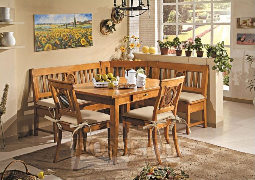 Eine hölzerne Essecke mit einer L-förmigen Bank, einem quadratischen Tisch und zwei Stühlen, alle mit beigefarbenen Polstersitzen.