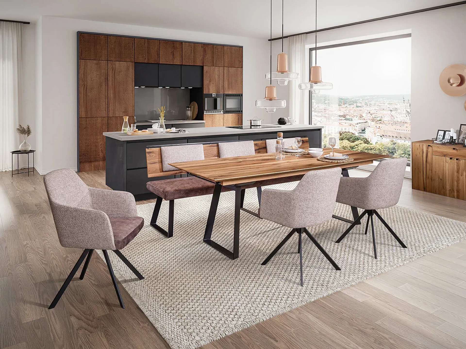 Modernes Esszimmer mit Holztisch, Bank, gepolsterten Stühlen und offener Küche mit dunklen Schränken.