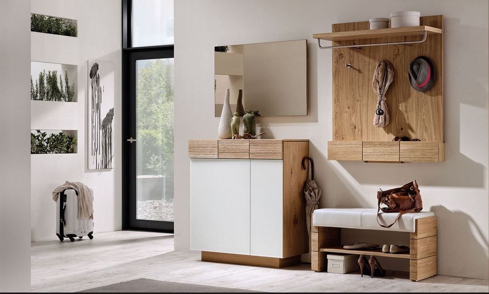 Modernes Eingangsbereich-Möbelset bestehend aus einem weißen Schrank mit hellen Holzelementen, einem Wandregal, einem Spiegel und einer gepolsterten Bank.