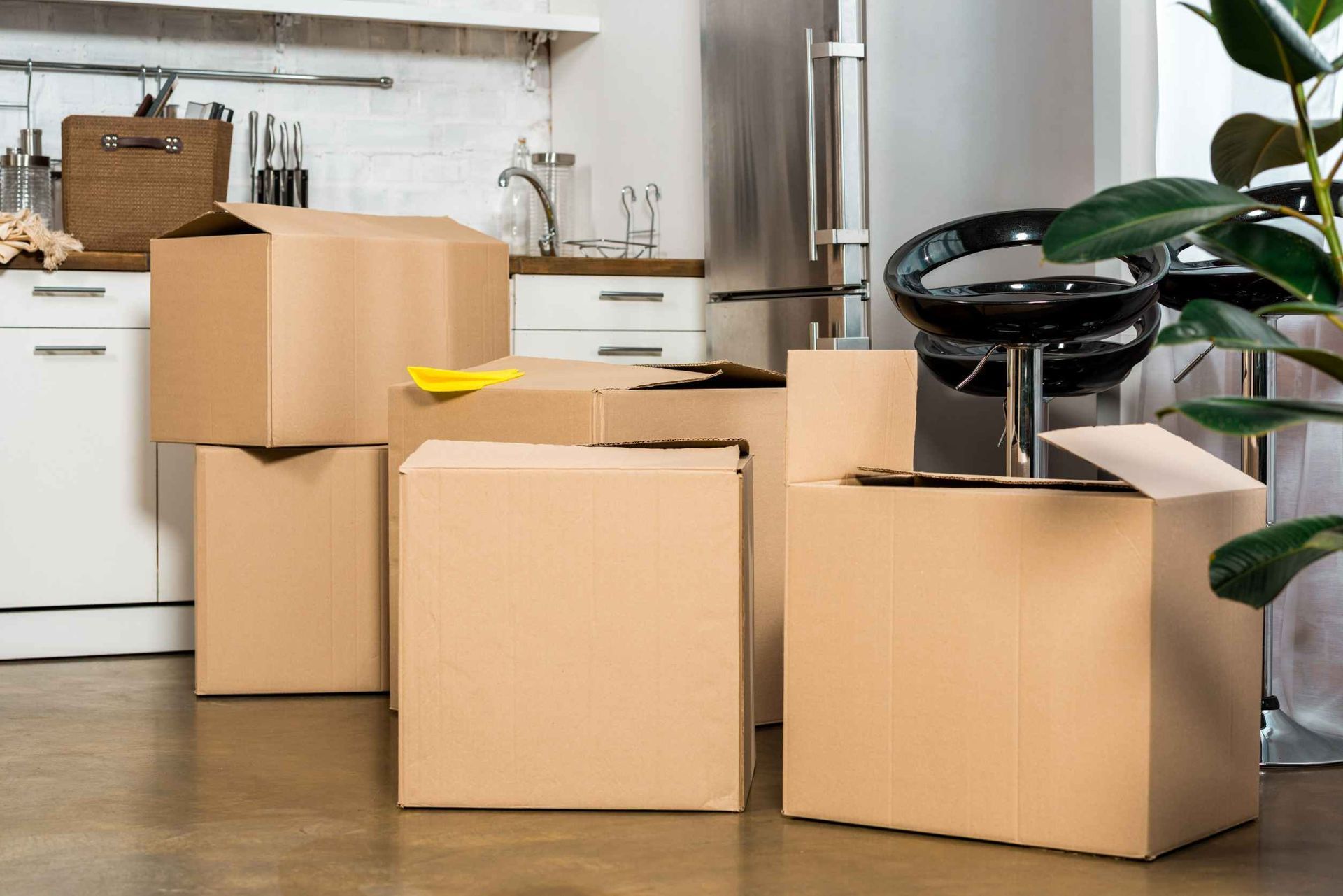 Un montón de cajas de cartón están apiladas una encima de otra en una cocina.