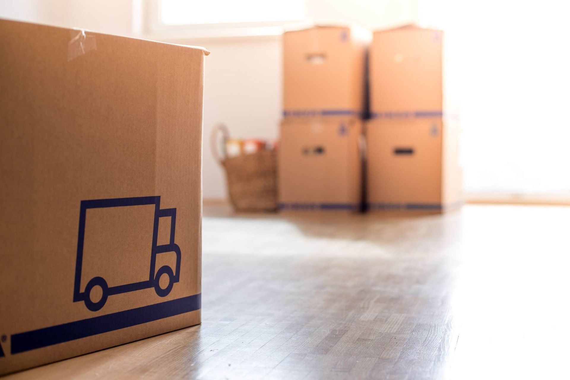 Una caja de cartón con un camión encima está en una habitación vacía.